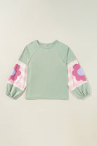 Sage oversized pullover with vintage flair, bubble sleeves, stripe pattern, exposed seams, and floral design on sleeves.