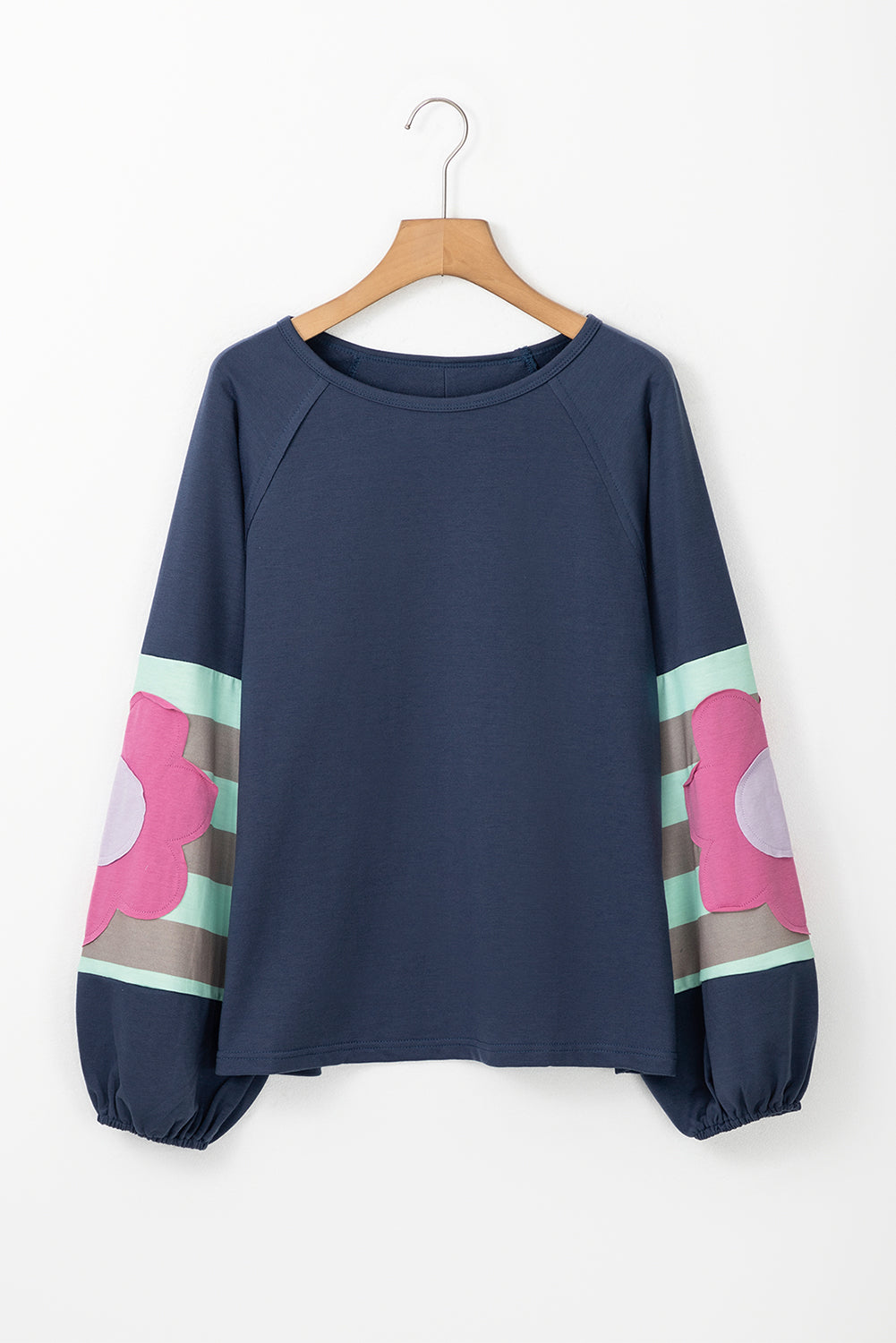 Blue oversized pullover with floral sleeve pattern, bubble sleeves, and raw cut details for a vintage flair.