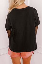 Back view of black Enchanted Moonlight Tee with floral mesh sleeves styled with pink shorts.