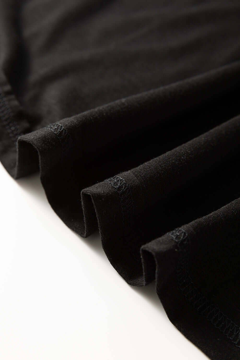 Close-up of the hem and fabric of the black Enchanted Moonlight Tee showcasing its soft texture.