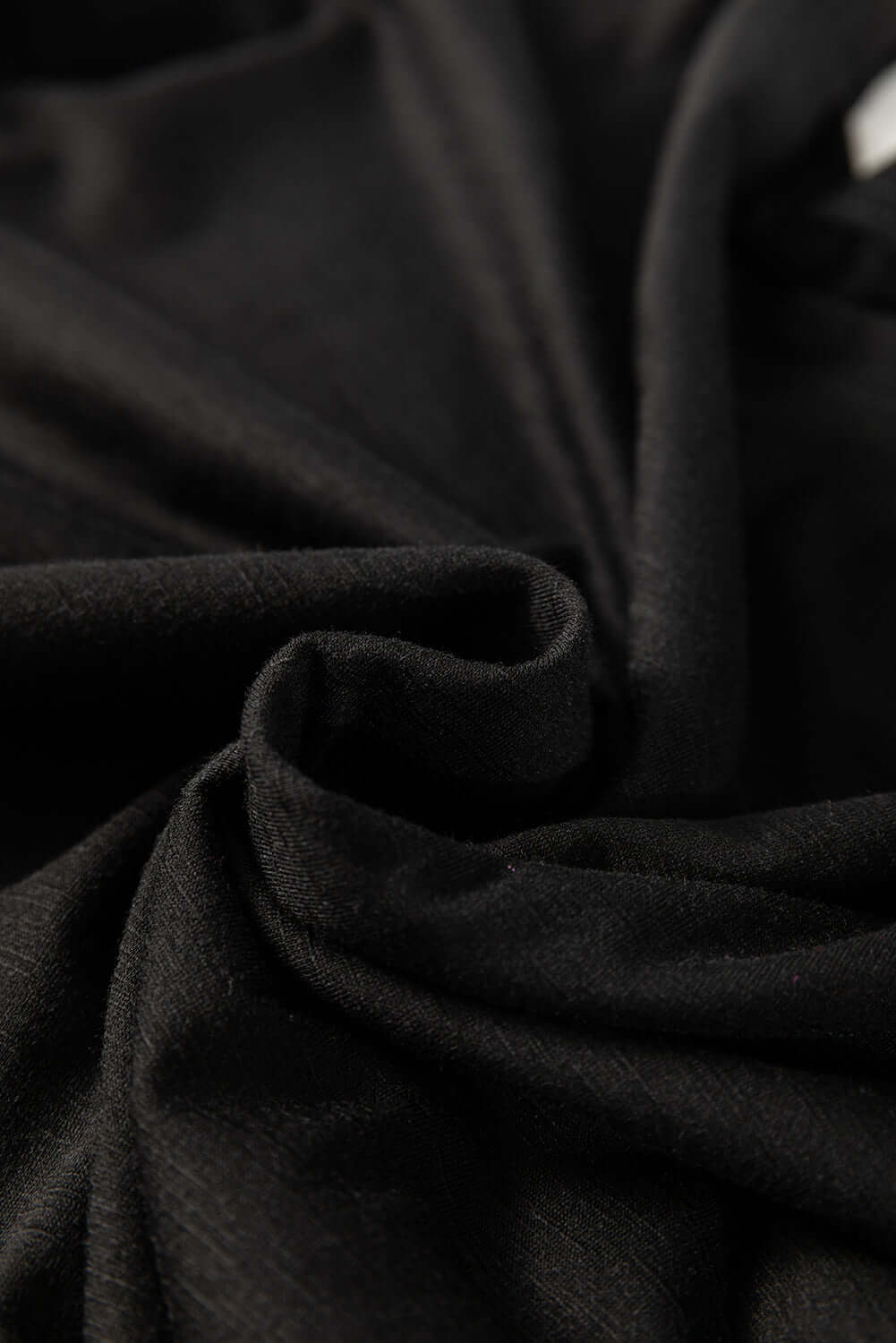 Close-up of soft black fabric, highlighting the smooth texture and elegant drape for comfortable clothing.