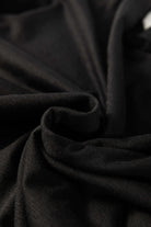 Close-up of soft black fabric, highlighting the smooth texture and elegant drape for comfortable clothing.