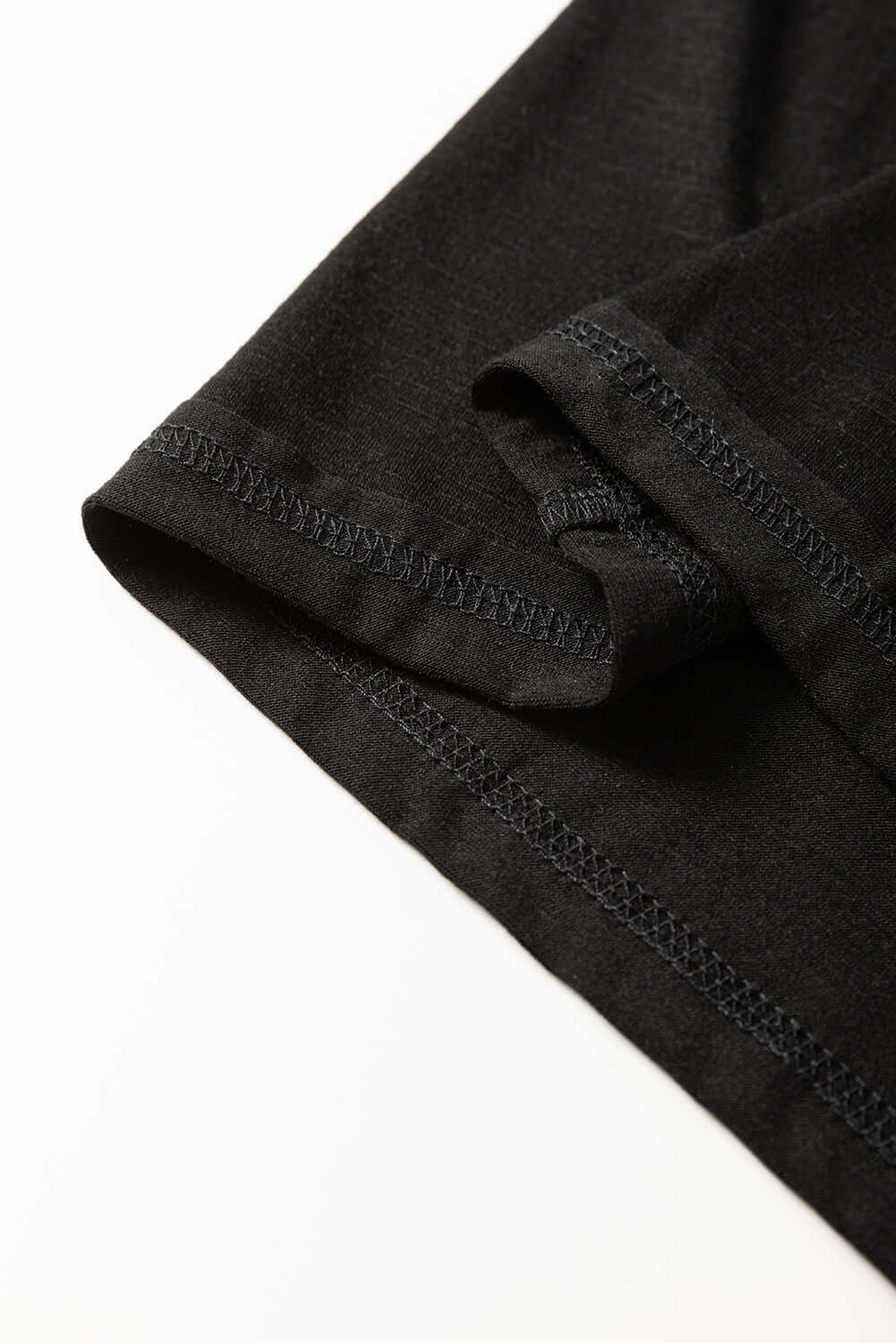 Close-up of the black Enchanted Moonlight Tee's sleeve showcasing soft fabric and stitched hem.