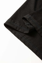 Close-up of the black Enchanted Moonlight Tee's sleeve showcasing soft fabric and stitched hem.