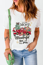 Woman wearing Most Wonderful Time T-shirt with red truck and gifts, perfect holiday apparel with crew neck and cuffed sleeves.