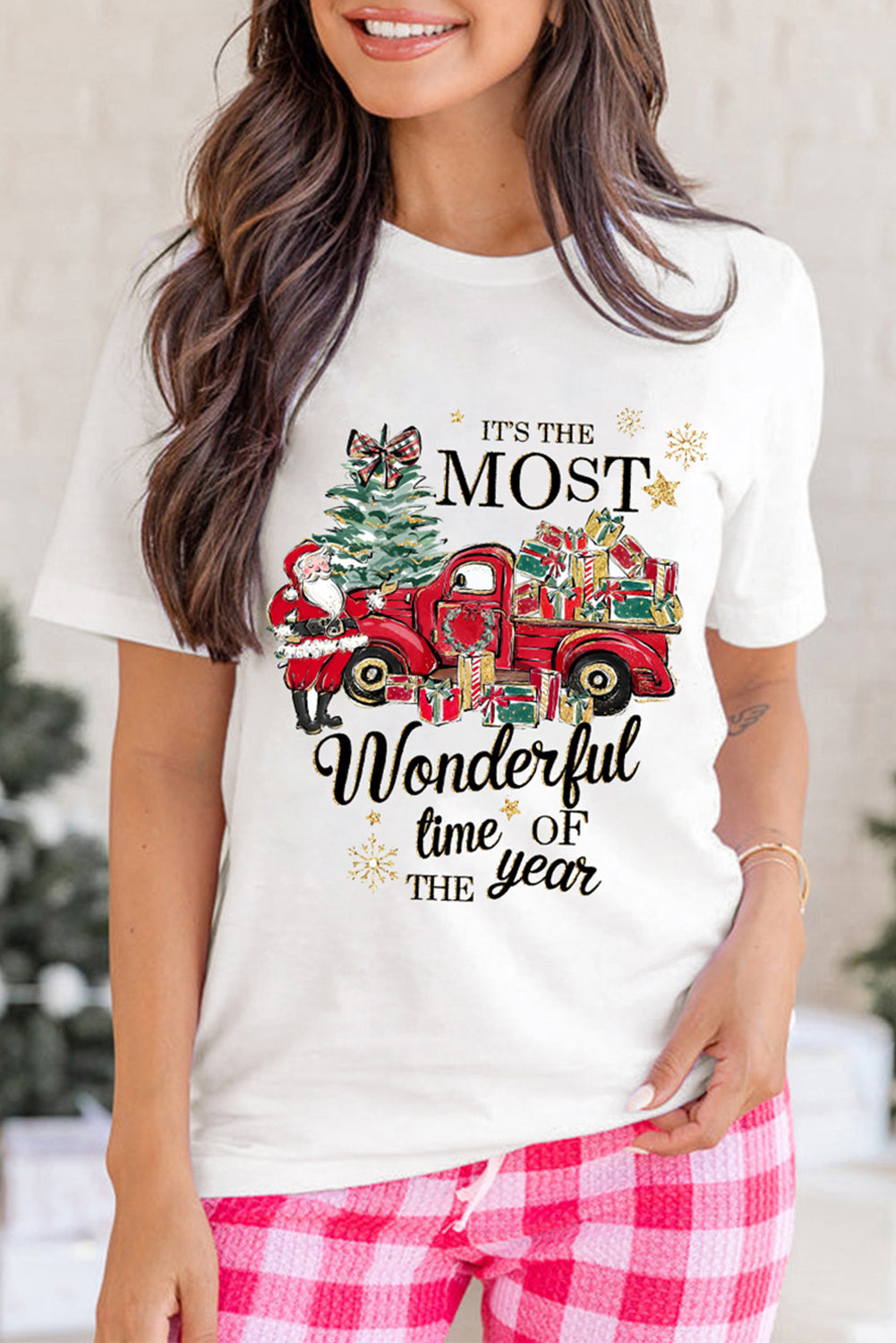 Woman wearing 'Most Wonderful Time' T-shirt with red truck and gifts, showcasing holiday spirit. Crew neck, short sleeves.