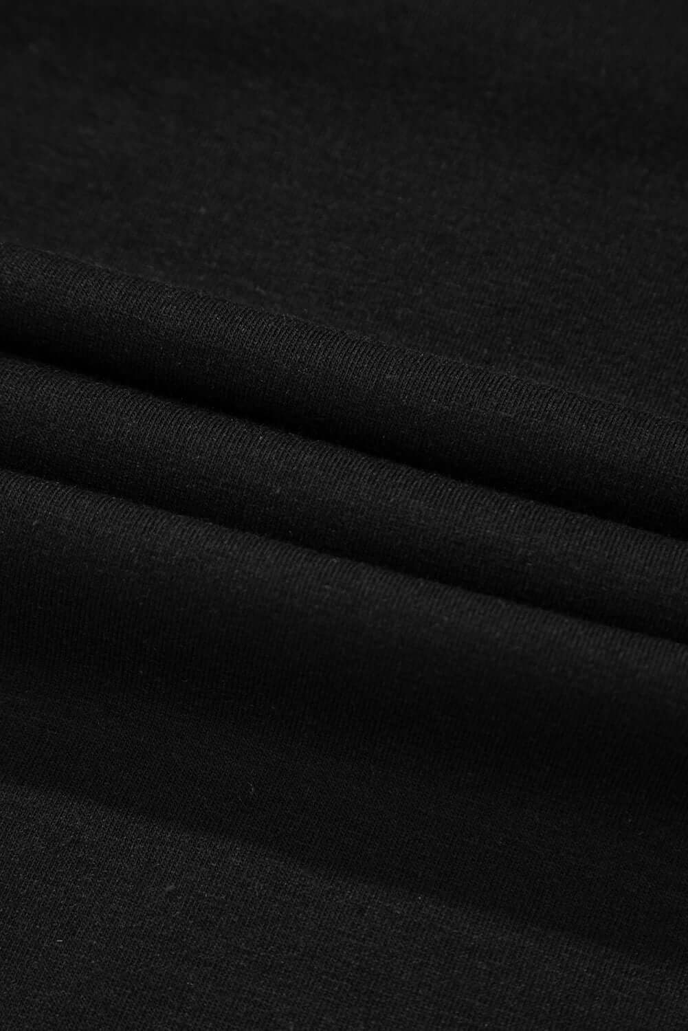 Close-up of soft black fabric showcasing smooth texture and drape for versatile apparel designs.