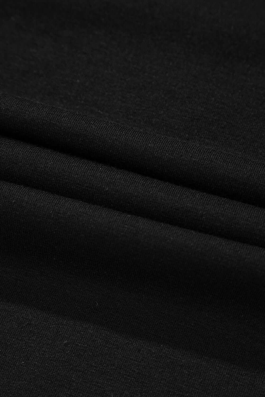 Close-up of soft black fabric with smooth texture, ideal for T-shirts and apparel.