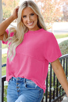 Model wearing a hot pink corded knit top with mock neckline, styled casually with jeans.
