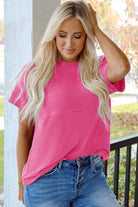 Hot pink knit top with mock neckline, paired with denim for a relaxed, stylish look.