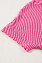 Close-up of hot pink corded knit top showcasing ribbed texture and short sleeves.