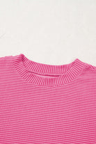 Close-up of a mock neckline in a hot pink corded knit top with textured stripes.