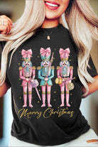 Festive T-shirt featuring playful pink and blue nutcrackers with "Merry Christmas" text, perfect for holiday celebrations.