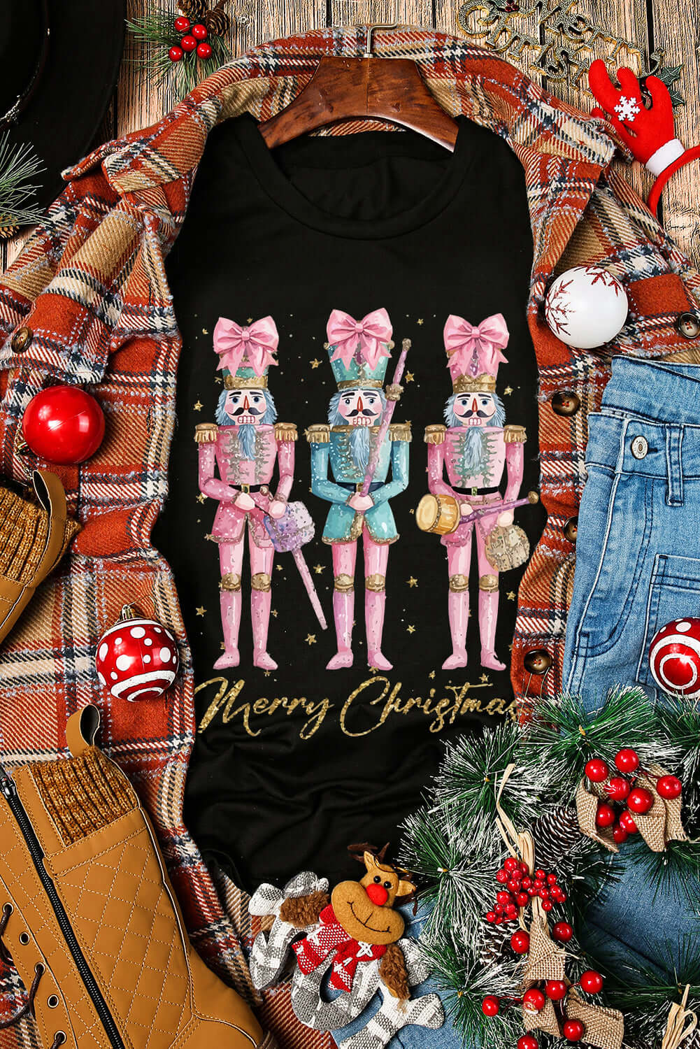 Festive Christmas T-shirt with nutcracker pattern and "Merry Christmas" text, surrounded by holiday decorations and plaid jacket.