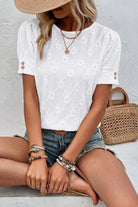 White Lattice & Lace Top with floral geometric texture, short sleeves, and buttoned cuffs, styled with denim shorts.