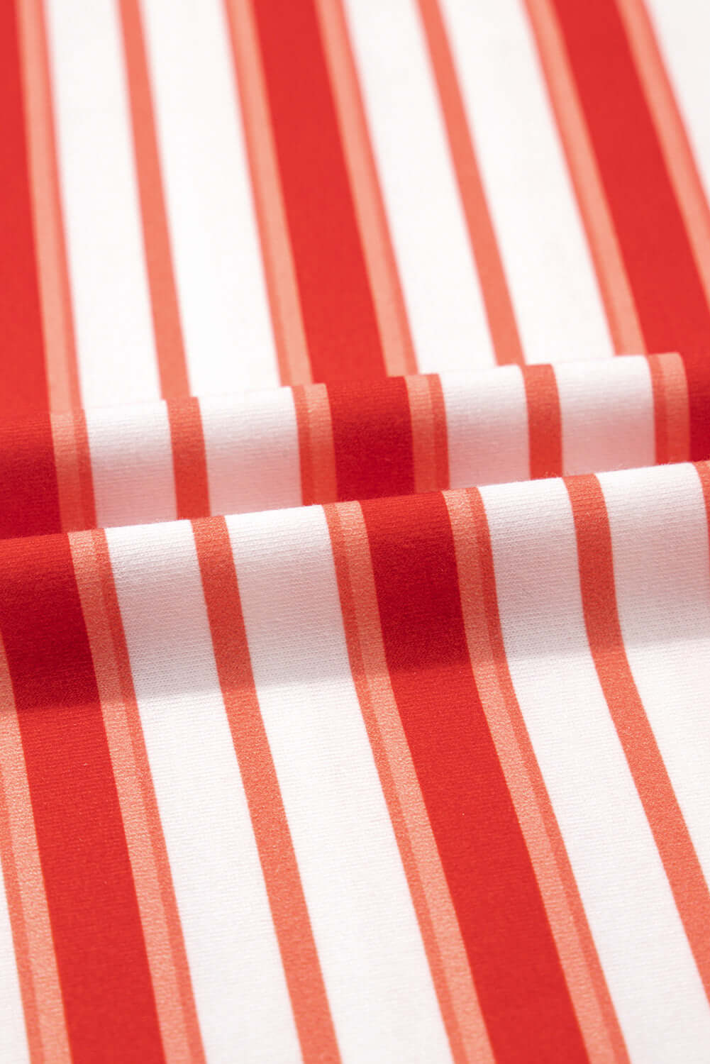 Close-up of tomato red and white striped fabric, perfect for summer style and laid-back Americana fashion.