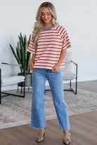 Model wearing Americana Mood Tee, a tomato red striped top with a blue collar and relaxed fit, paired with light blue jeans.