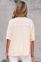 Back view of the Happiness Blooms Top in vanilla, showcasing its relaxed fit and exposed stitching details.