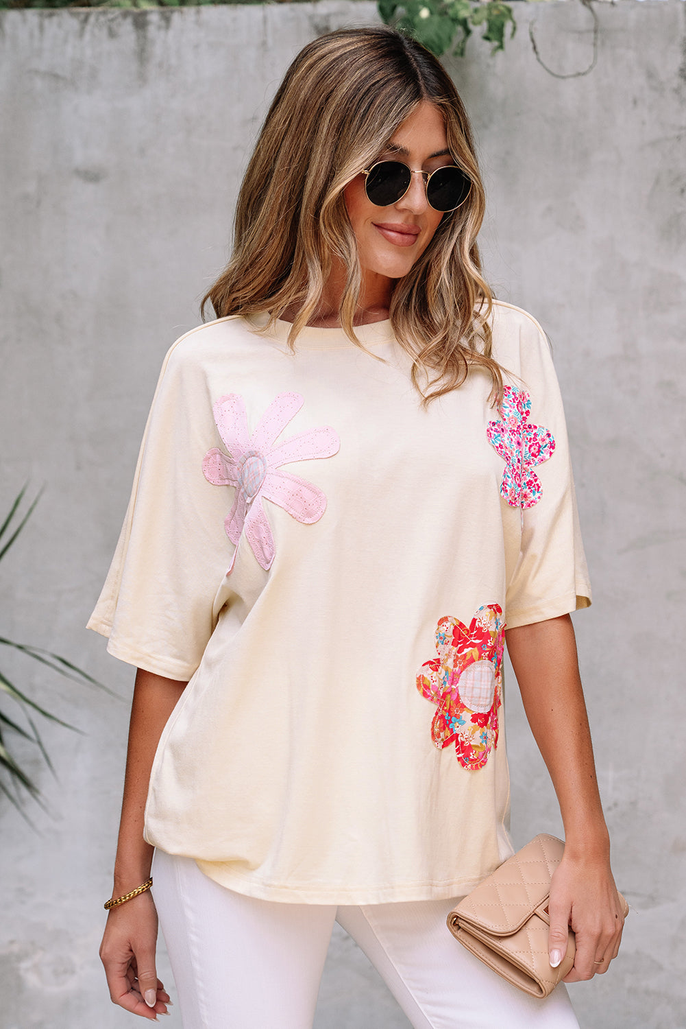 Woman wearing a vanilla floral patch top with relaxed fit and exposed stitching against a neutral background.