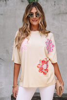 Women’s vanilla cream tee with floral patches and exposed stitching, perfect for casual chic styling.