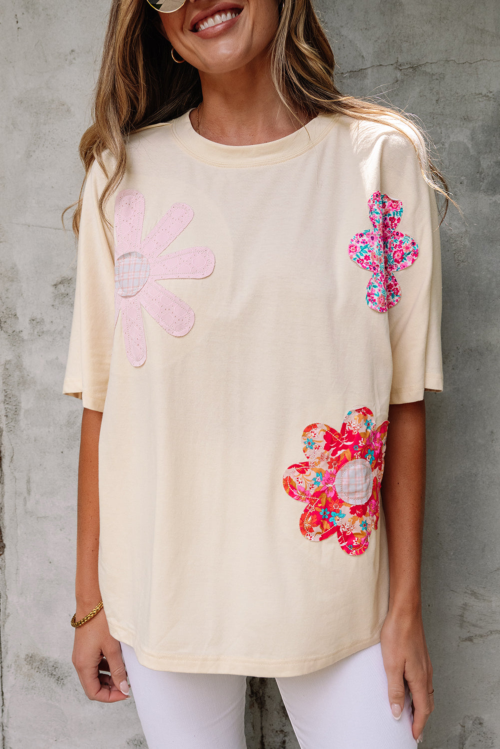 Vanilla cream top with playful floral patches and exposed stitching for a relaxed, artsy look.
