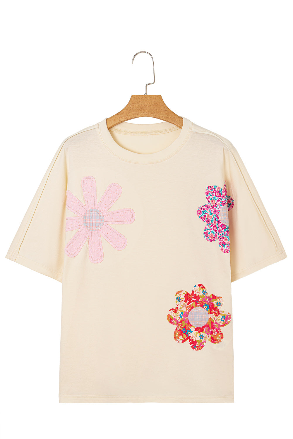 Vanilla tee with colorful floral patches and exposed stitching for a relaxed, stylish look.