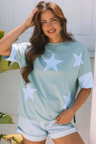 Oversized sage tee with sky blue star patches, frayed details, perfect for a casual street-style look.