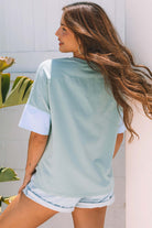 Cosmic Crush oversized star patch tee in sage with blue sleeves, showing back view on model in a casual outdoor setting.