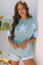 Model wearing Cosmic Crush Top in sage and sky with star patches, styled for a casual summer look.