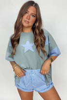 Oversized sage star patch tee paired with striped shorts, showcasing a relaxed street-style look.
