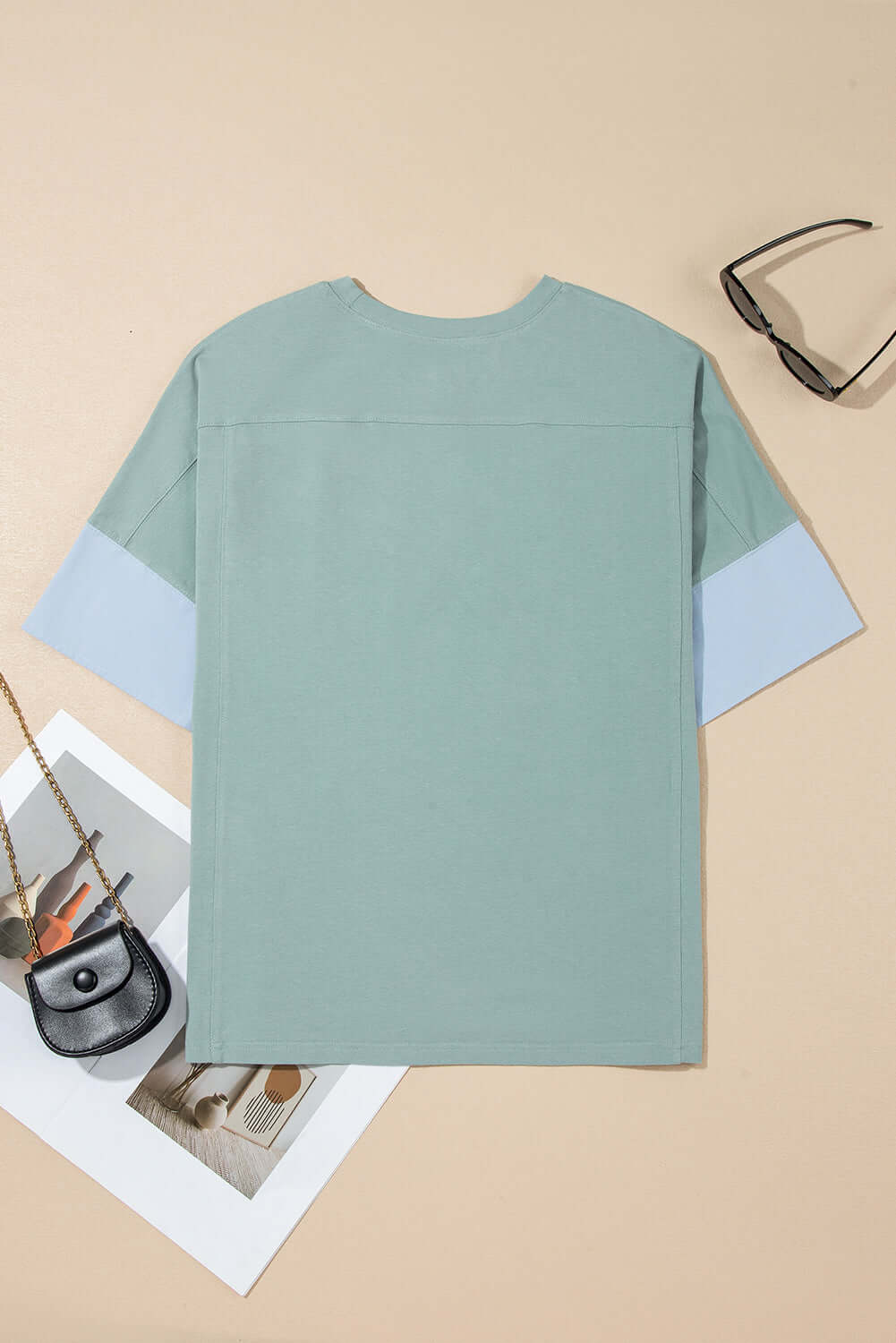 Back view of the Cosmic Crush Top in sage and sky blue, showcasing oversized design and frayed details.