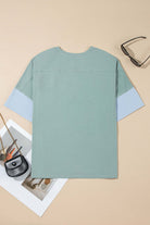 Back view of the Cosmic Crush Top in sage and sky blue, showcasing oversized design and frayed details.