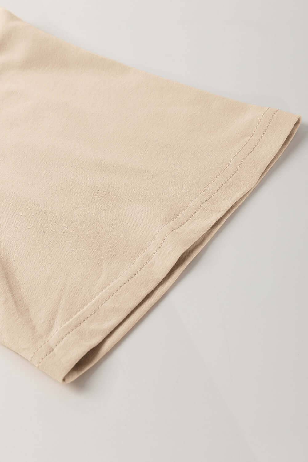 Close-up of the relaxed drop shoulder design of the Morning Daisy top in soft beige fabric.