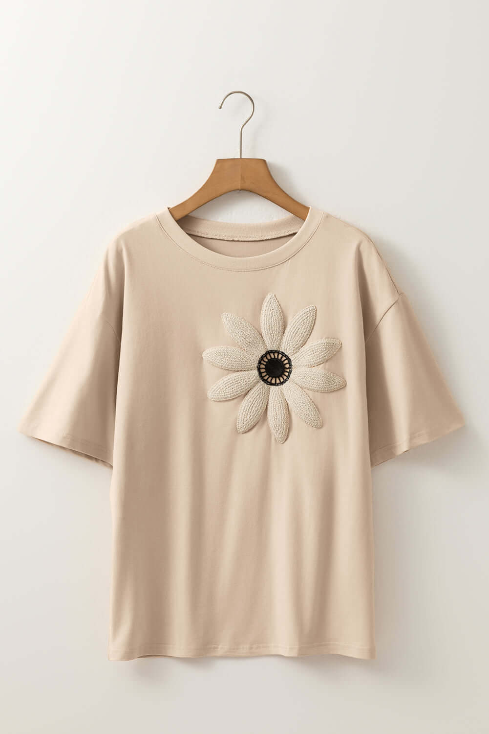 Morning Daisy top featuring a crochet floral graphic on a beige loose tee with drop shoulder design.