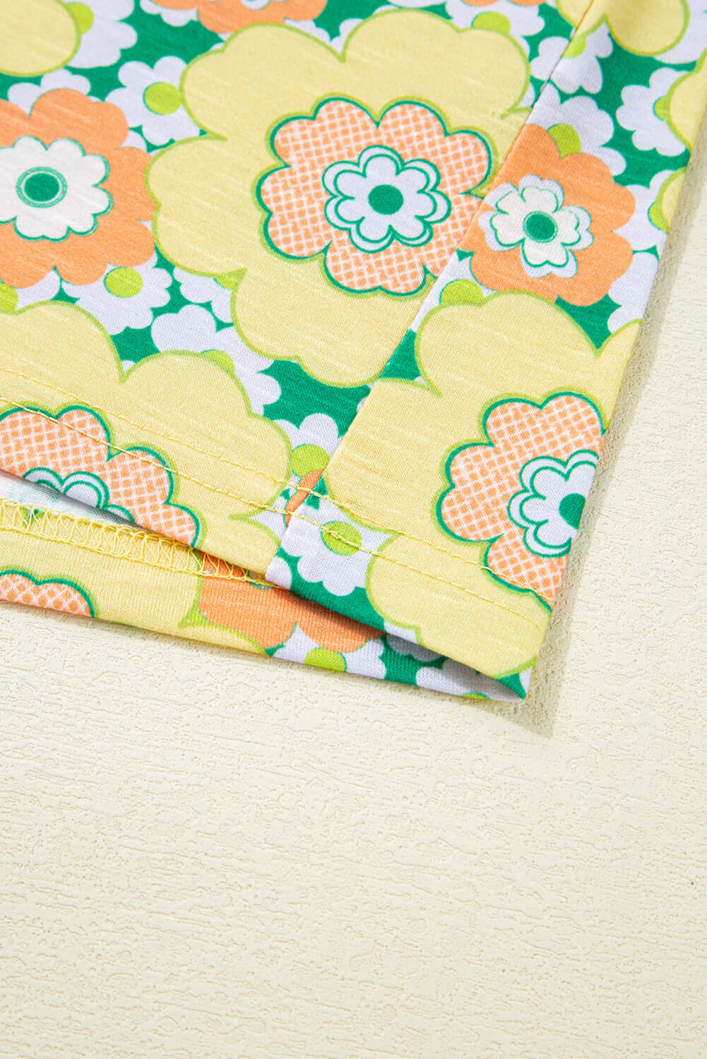 Close-up of the yellow floral print on the Daisy Disco Top, showcasing retro flower patterns and vibrant colors.
