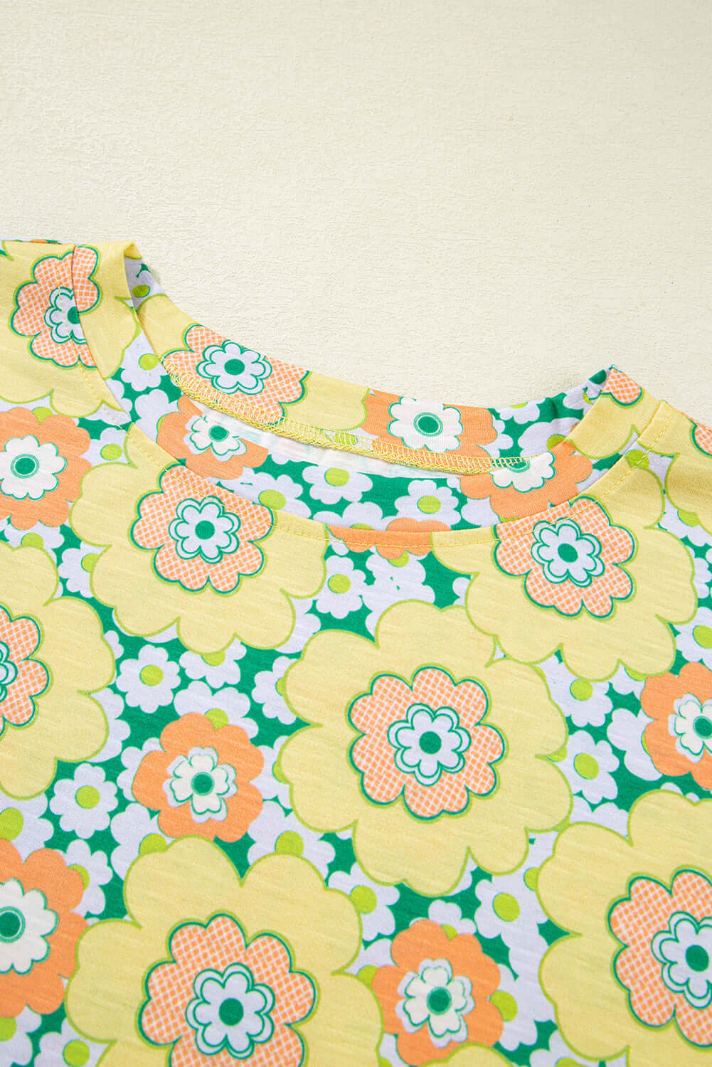 Yellow floral print tee with green and orange flowers, featuring a drop shoulder design for a relaxed fit.