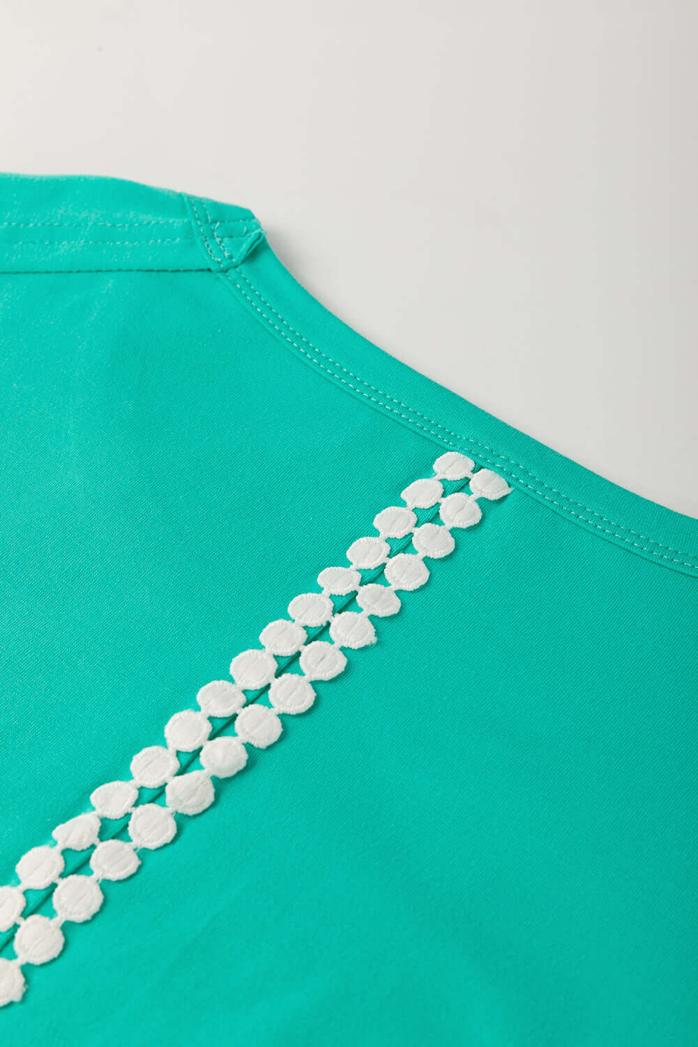 Teal lace detail on the back of Ribbon Theory Top showcasing playful and stylish design.