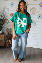 Teal lace bow top paired with wide-leg jeans, showcasing playful style and casual comfort.