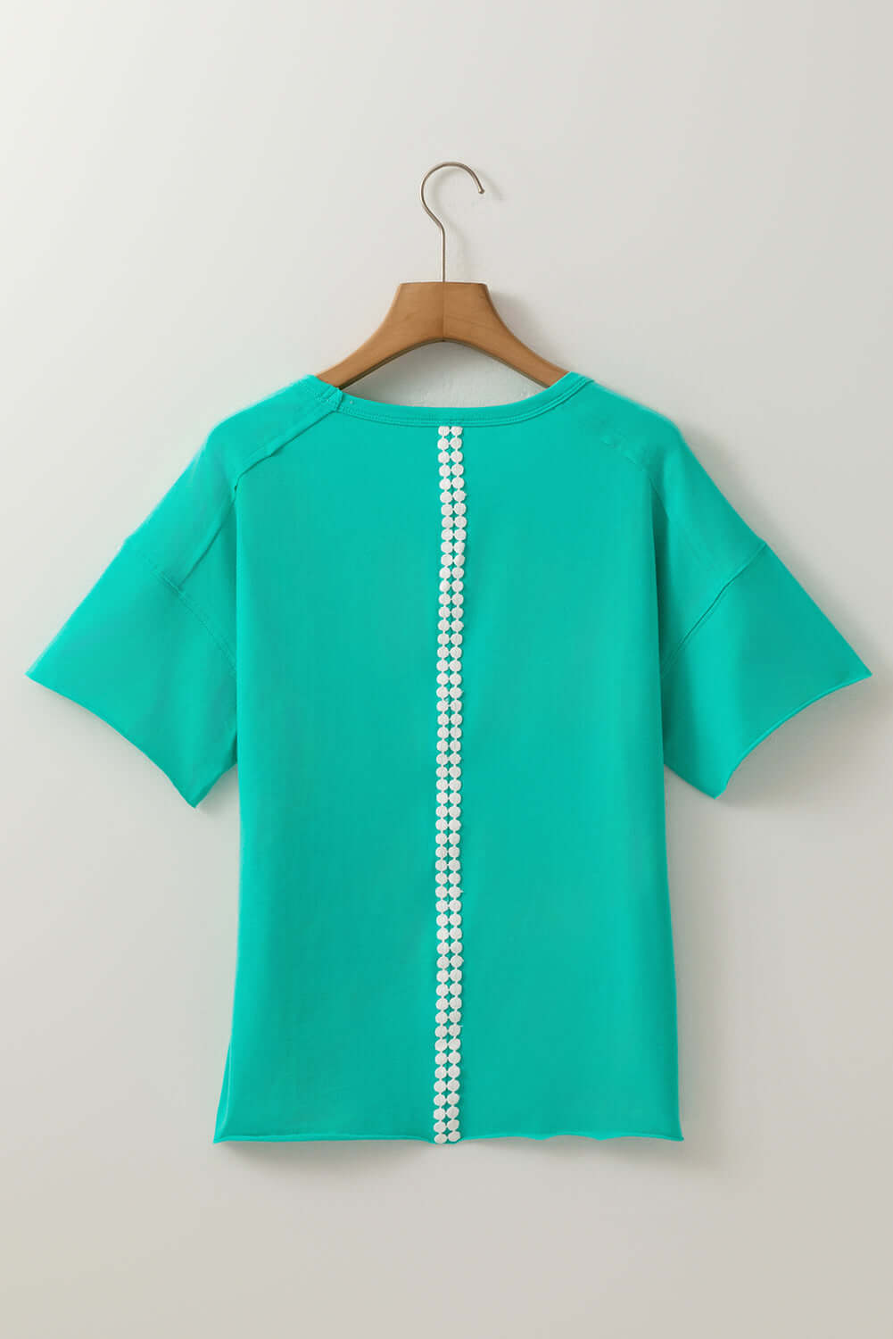 Back view of Ribbon Theory Top in teal, featuring a unique lace trim down the center and relaxed fit sleeves.