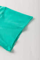Teal lace bow raw edge tee sleeve detail of the Ribbon Theory Top, showcasing its playful and stylish design.