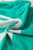 Teal lace bow detail on a raw edge tee, showcasing playful and stylish fashion elements.