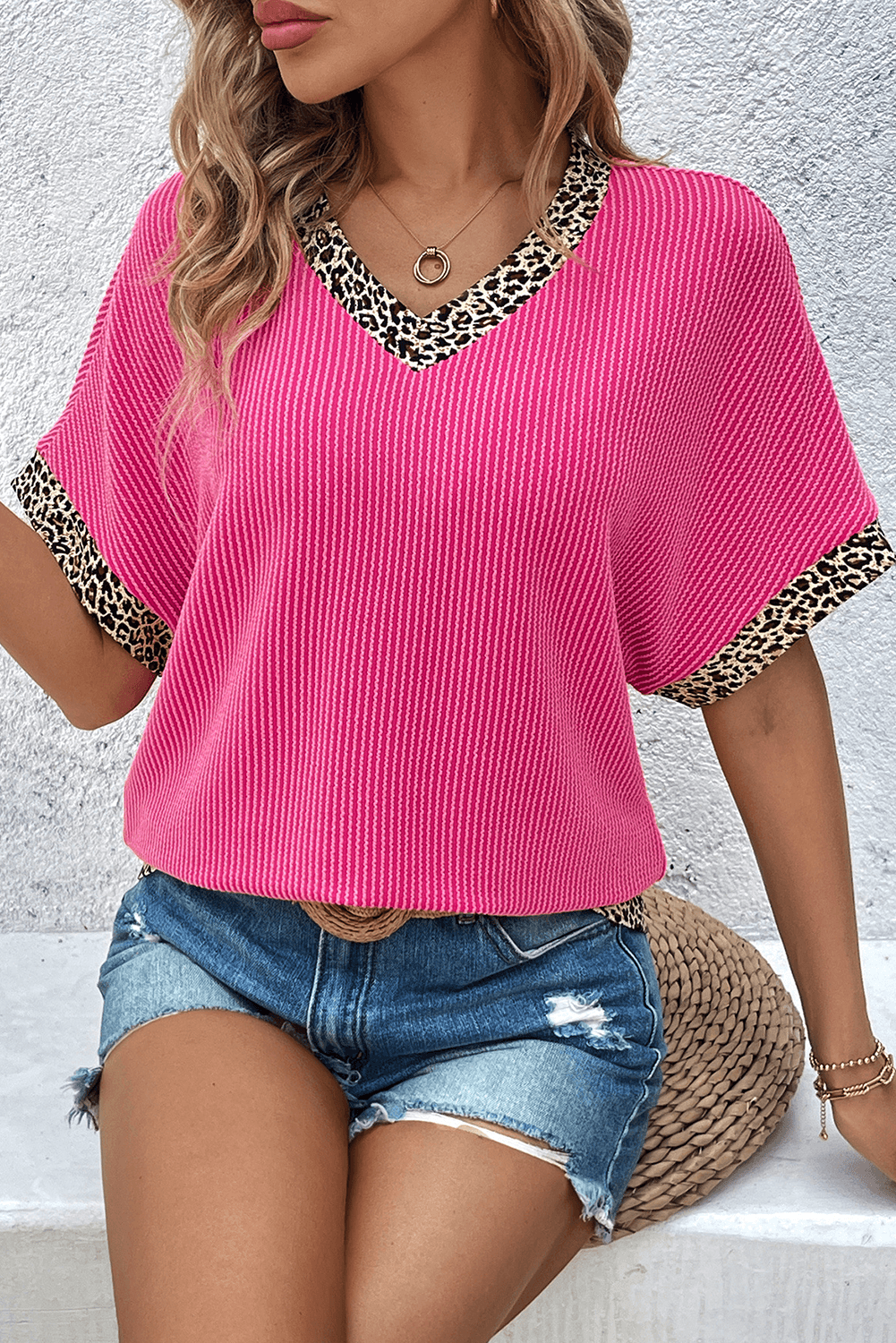 Bright pink leopard patchwork V-neck top paired with denim shorts for a chic casual look.