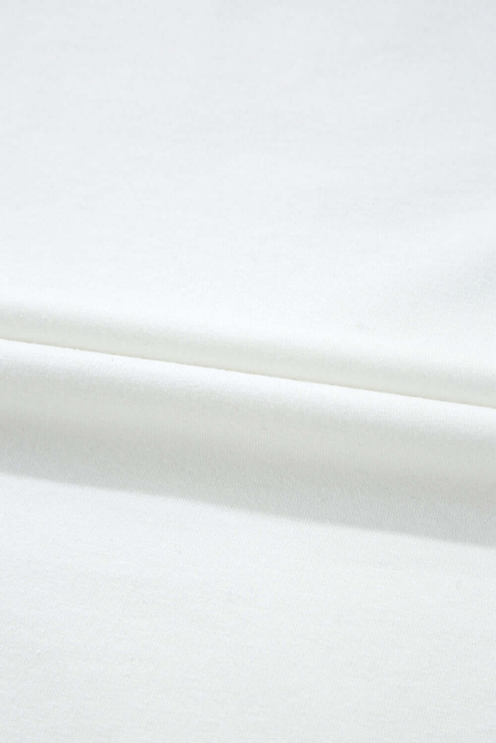 Close-up of soft white fabric, showcasing the smooth texture ideal for Laced Logic Top.