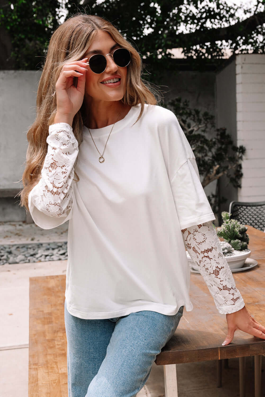 Model wearing Laced Logic Top with white lace long sleeves, blending chic style and comfort in a casual setting.