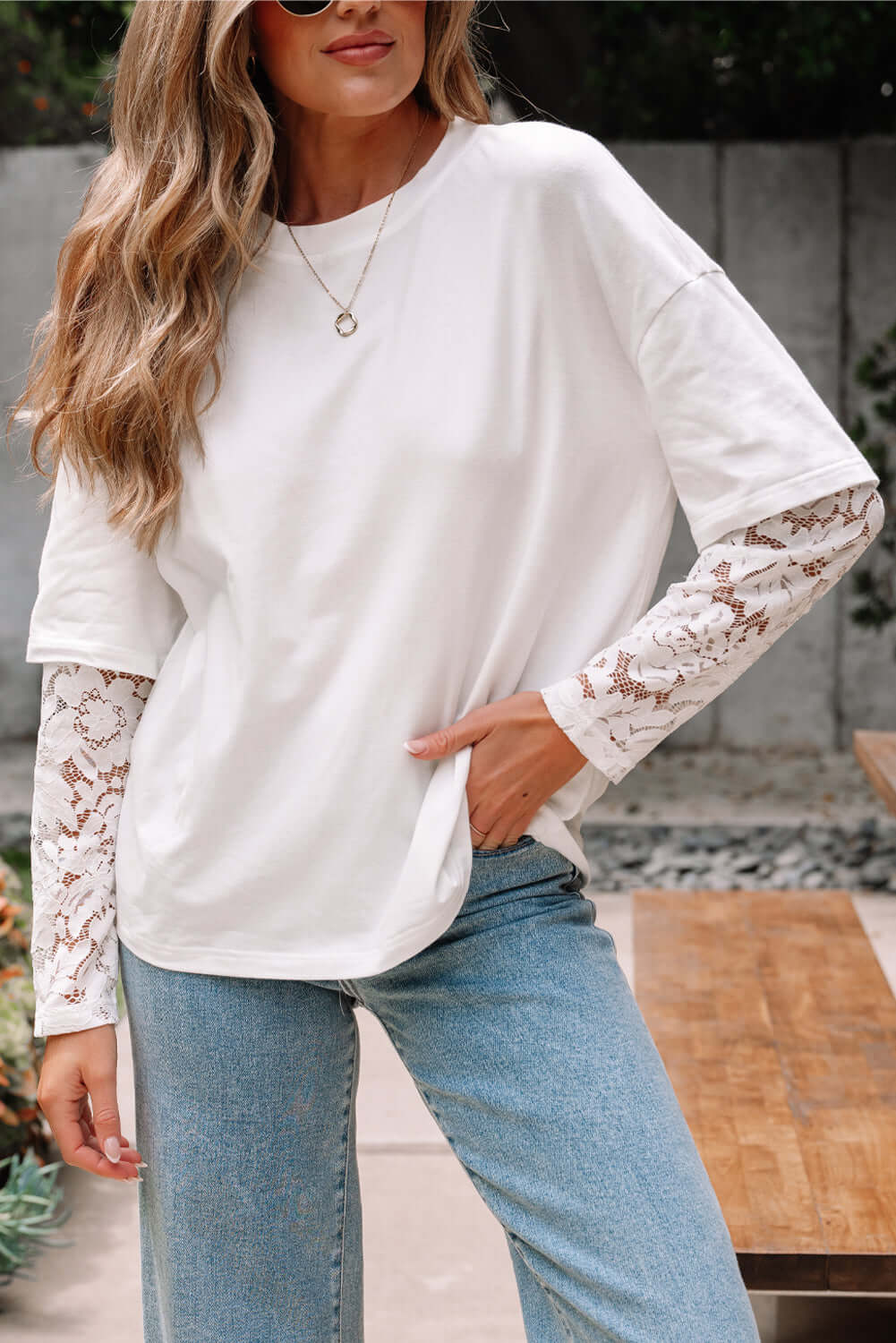 Model wearing Laced Logic Top, a white tee with lace long sleeves, styled casually outdoors.