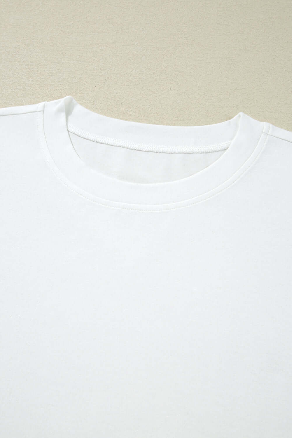 Close-up of the neckline of the Laced Logic Top showcasing its clean, minimalist white design and soft fabric.