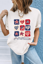 Woman wearing a white graphic tee featuring red, white, and blue hearts and stars with 'America' text.