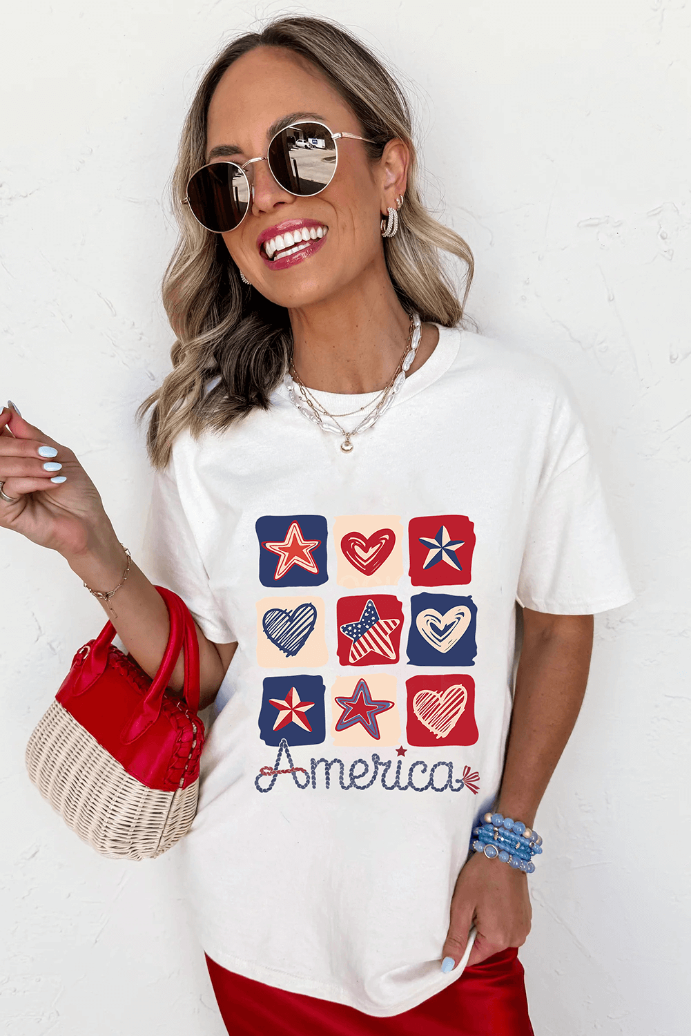 Model wearing Land That I Love Tee with festive hearts and stars design, perfect for patriotic celebrations.