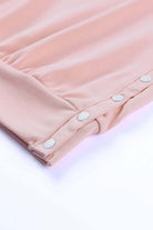 Close-up of BASHFUL BEAUTY top's chic slit button design in soft pink fabric, showcasing cozy and stylish details.