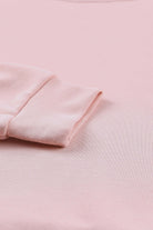 Close-up of the soft pink fabric and cuff of the BASHFUL BEAUTY Top by Vivian-Lu, showcasing its cozy and stylish design.